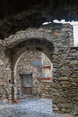 Triora 'nın ortaçağ köyünde taş kemerli sokak manzarası. Imperia eyaletinde yer alan yüksek Valle Arjantin (Arjantin Vadisi), aynı zamanda cadıların şehri olarak da bilinir..