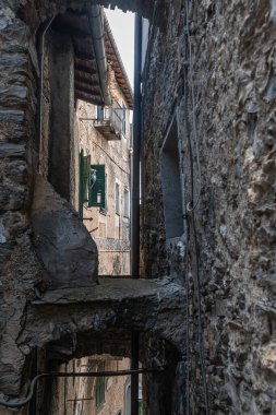 Triora 'nın ortaçağ köyünde taş kemerli sokak manzarası. Imperia eyaletinde yer alan yüksek Valle Arjantin (Arjantin Vadisi), aynı zamanda cadıların şehri olarak da bilinir..