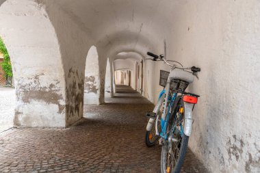 Architectural details of chalky, whitewashed arcades and arch passageway alley in the ancient city of Glurns, South Tyrol, Italy clipart