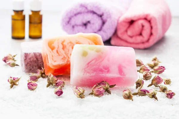 Spa setting with rolls  towels,  natural soap and  rose flowers,  selective focus, shallow depth of field