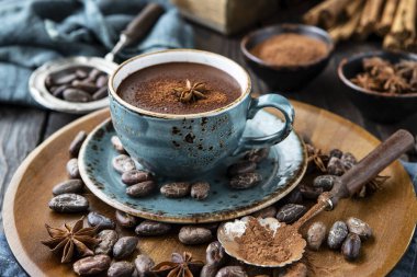 Ahşap arka planda seramik bardakta kalın baharatlı sıcak çikolata.