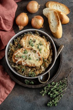 Geleneksel Fransız soğan çorbası, kızarmış ekmek, peynir ve kekik.