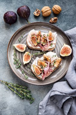 Kahvaltı için krem peynirli, jambonlu ve incirli leziz bruschetta.