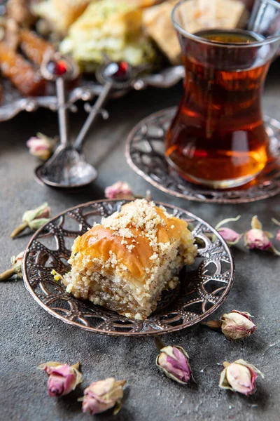 Geleneksel bakır servis setinde Türk çayı ve baklava 