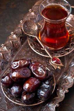Geleneksel bakır servis setinde tarihi meyvelerle dolu cam bardakta Türk çayı, sığ alan derinliğinde seçici bir odak