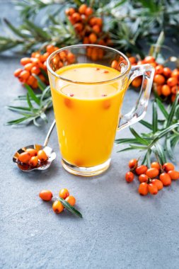 Cam fincanda taze böğürtlen ve yapraklı deniz dikenli çay. Bitki vitamin çayı.