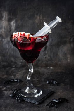 Cadılar bayramı alkollü kokteyl kanlı Martini korkunç karanlık arka planda kan ve örümcekler, vampir partisi için şenlikli içki.