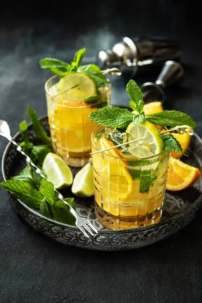 Erfrischendes Getränk Mit Limetten Orangen Zitronen Und Minzblättern Auf Dunklem lizenzfreie Stockbilder