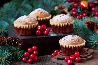 Kırmızı böğürtlenlerle süslenmiş ahşap kırsal ve Noel ağacı dallarında vanilyalı çörekler. Kış tatili geçmişi