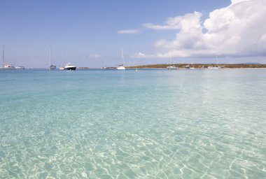 Açık mavi okyanusta yelkenli teknesi olan sakin bir sahil. SESpalmador, Formentera Adası. Baleares İspanya