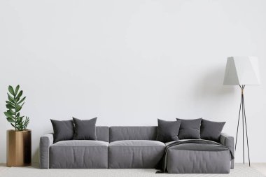 Büyük beyaz oturma odası. İç tasarım. Gri kanepe, lamba, ahşap masa.