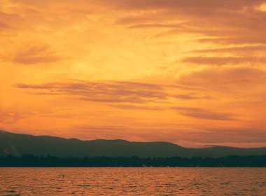 Dağda günbatımının huzurlu bir gölle çekilmiş bir fotoğrafı. Idyllic günbatımının manzarası.
