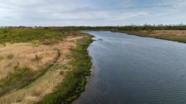 Okyanusa insansız hava aracı manzarası ve yeşil çimlerle kaplı sahil şeridi. Günün sonunda parkta gerçek bir doğa videosu var..