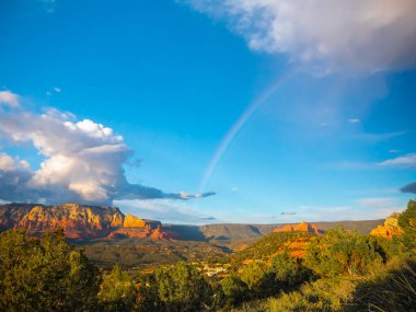 Arizona 'da gün batımında gökkuşağı. Gökyüzünde gökkuşağı olan panoramik dağlar.