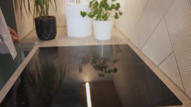 Kadın modern bir mutfakta cam bir tencereyi temizliyor. Ev bakımı, temizlik ve günlük rutin konsept