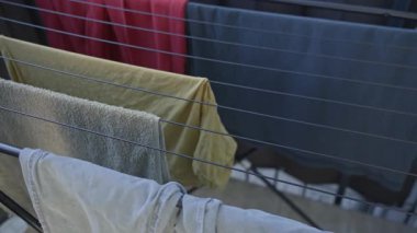 Temiz havlu ve giysiler dışarıdaki kuru askının üzerine yerleştirilmiş. Çevre dostu yaşam tarzı ve ev rutini kavramı