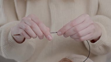 Bir zanaat projesi için örgü iğnelerinin parçalarını birleştiren kadın
