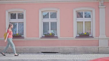 Kentsel bahar yürüyüşü çiçek açan pencerelerin ve klasik dış görünüşün yanından geçiyor