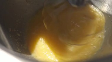 Sıvı hamuru metal bir kase karıştırıcıda kırbaçlanıyor. Pişirme hazırlığı ve yumurta karışımı