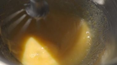 Yumurta bazlı karışım güçlü bir şekilde karıştırma kabında çırpılıyor. Mutfak süreci, ev yapımı ya da tatlı hazırlama.