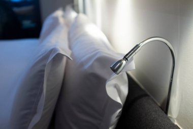 Yatağın üstünde lamba okuyordum. İç mobilyaların üzerinde hala beyaz yastıklar vardı.