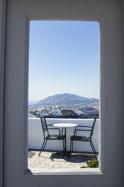 Santorini Adası 'nın güzel ufuk çizgisi manzaralı romantik bir sahnede iki sandalye, Yunanistan' ın pencere çerçevesi