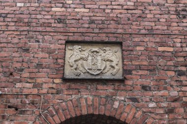 Riga, Letonya 'da eski bir tuğla duvarda eski bir ortaçağ kalkan taşı