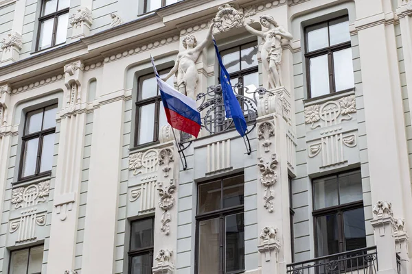 Russian and european flags waving in a balcony in Riga, Latvia