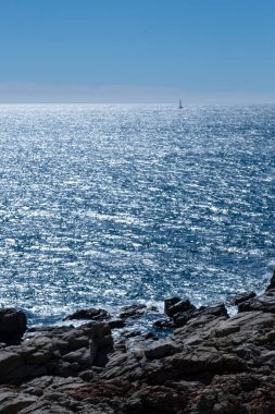 Akdeniz 'de sakin mavi sularda seyreden küçük bir tekne. Yaz tatillerinde mavi deniz manzarası.