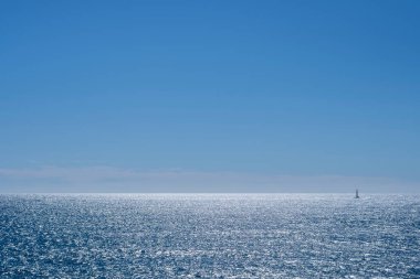 Akdeniz 'de sakin mavi sularda seyreden küçük bir tekne. Yaz tatillerinde mavi deniz manzarası.