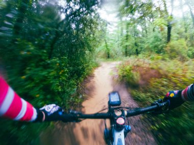 Dağ bisikletini tek bir pistte sürmek, çamurlu bir orman manzarasında motosiklet sürmek...