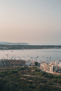 Mellieha Körfezi 'nde gün batımının güzel manzarası. Akdeniz' deki Malta Adası 'nda bazı kayıklar var.