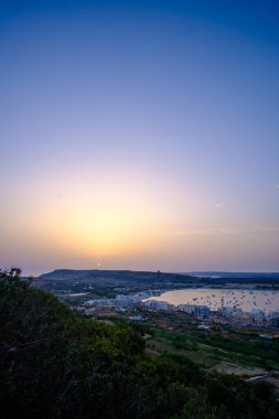 Mellieha, Malta Adası, Akdeniz 'in güzel kıyı kasabasında gün batımı manzarası