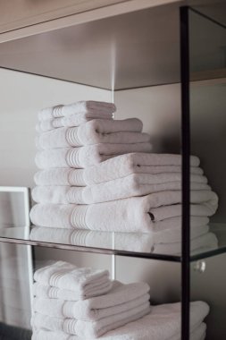 Bir otel odasında arka arkaya bir sürü beyaz havlu.