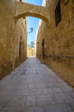 Gozo, Malta 'da eski binaları olan eski bir taş sokak.