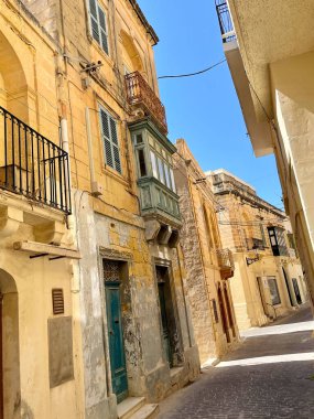 Gozo, Malta 'da eski binaları olan eski bir taş sokak.