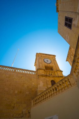 Gozo, Malta 'da eski ve güzel bir duvarın köşesindeki saat kulesi.