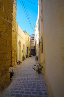 Malta 'nın Gozo şehrinde kaldırım taşları olan güzel eski dar sokaklar.