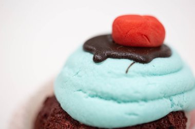 Beyaz arka planda izole edilmiş parlak mavi şekerli kırmızı kadife kek.