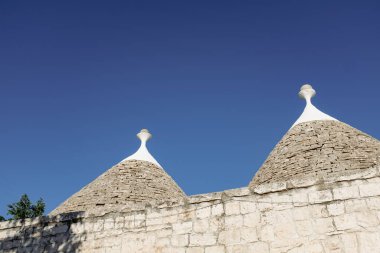 Güney İtalya 'daki Trulli evlerinin tipik koni çatısı, Puglia Alberobello güneşli bir günde