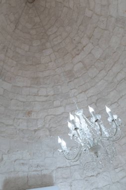 Trulli 'lerin evinin çatısındaki koni kaplı bir konide avize beyaz lamba.