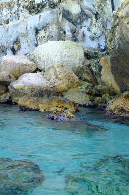 İtalya 'nın Puglia kentindeki şeffaf turkuaz Akdeniz sularında küçük su dalgaları