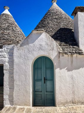 Güney İtalya 'da Alberobello' da koni şeklinde kaya çatıları olan geleneksel beyaz evler.