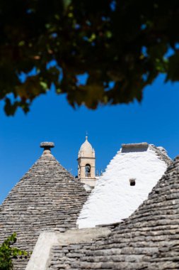 İtalya 'nın Alberobello şehrinde kayalardan ve taşlardan yapılmış güzel koni şekilli tavan çatıları olan bir şehrin silueti.