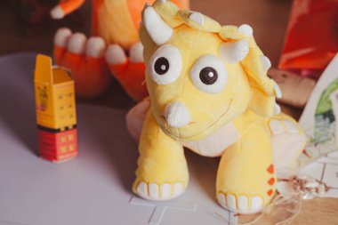 Şirin sarı pelüş dinozor oyuncağı. Yaklaş.