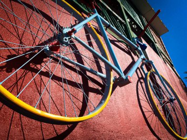 Kırmızı bir duvarda eski paslı mavi bisiklet süslemesi