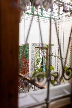 Fas 'ta bir Ryad otelinde renkli bir pencere mobilyasındaki eski metal çit.