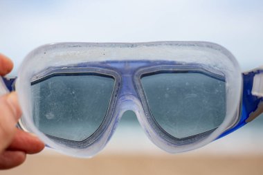 Sualtı Google lensleri kahverengi ve mavi bir plaj arka planına yakın