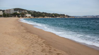 Costa Brava 'da sakin suları olan bir sahilde kumsalda ayak sesleri.