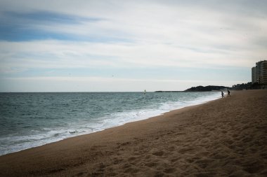 Costa Brava 'da sakin suları olan bir sahilde kumsalda ayak sesleri.